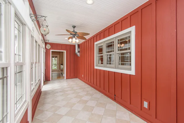 an empty room with windows and fan