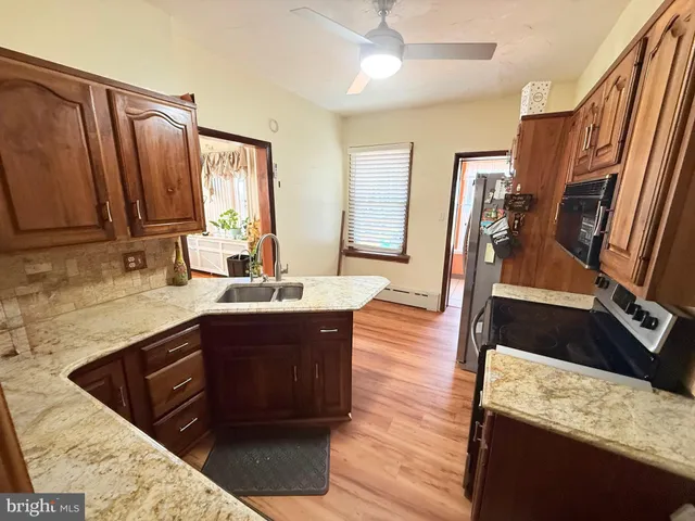 a spacious bathroom with a granite countertop double vanity sink a mirror and a bathtub