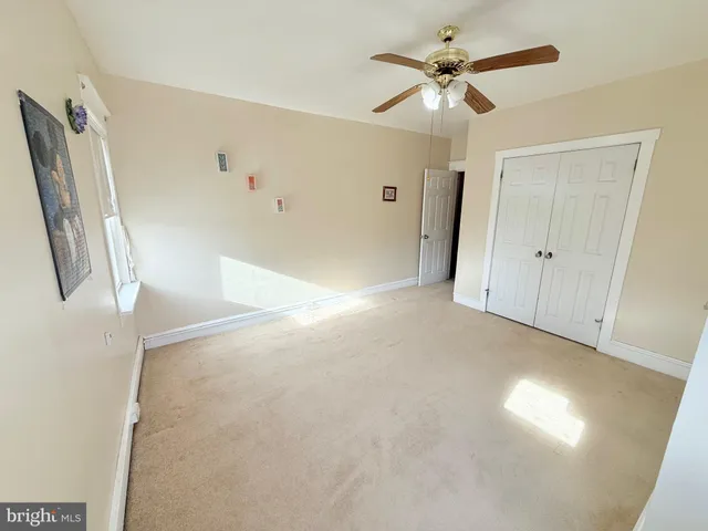 a view of a livingroom with a ceiling fan and window