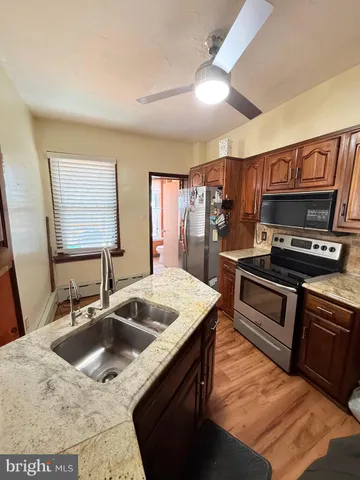 a kitchen with stainless steel appliances granite countertop a sink and a refrigerator