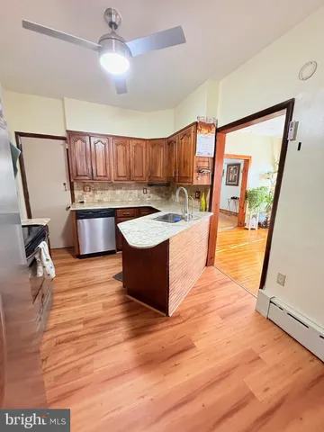 a living room with stainless steel appliances granite countertop furniture wooden floor and a large window