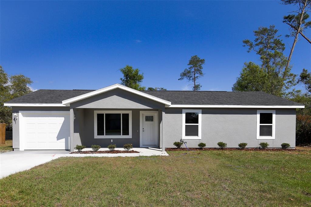 2463 Southwest 144th Pl Road Ocala, FL 34473 - Photo 1 of 1 a front view of a house with a yard
