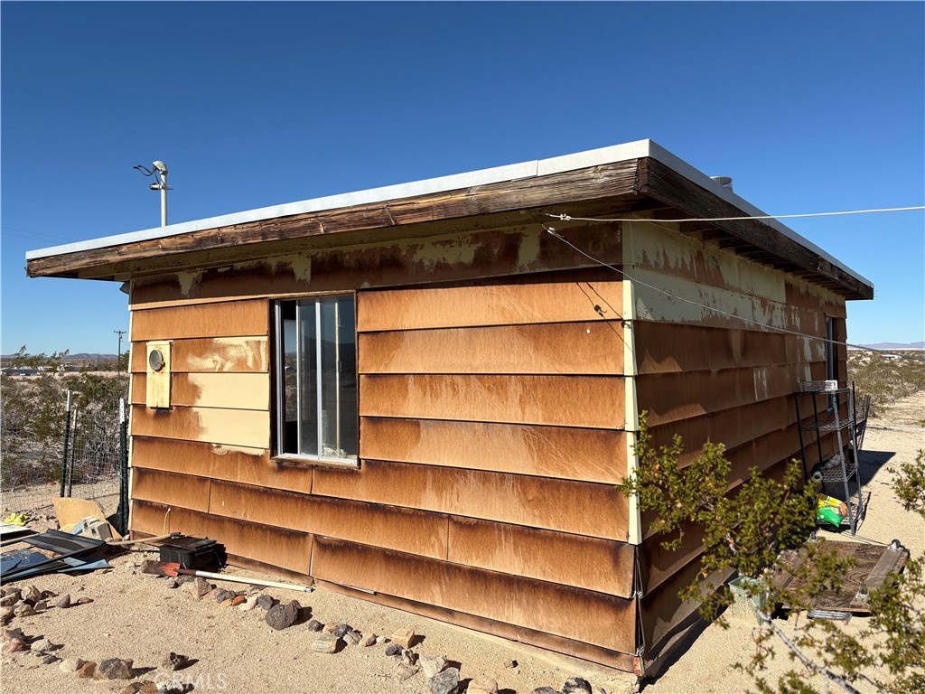 64815 Carot Road Joshua Tree, CA 92252 - Photo 4 of 11 a view of wooden house with a large window