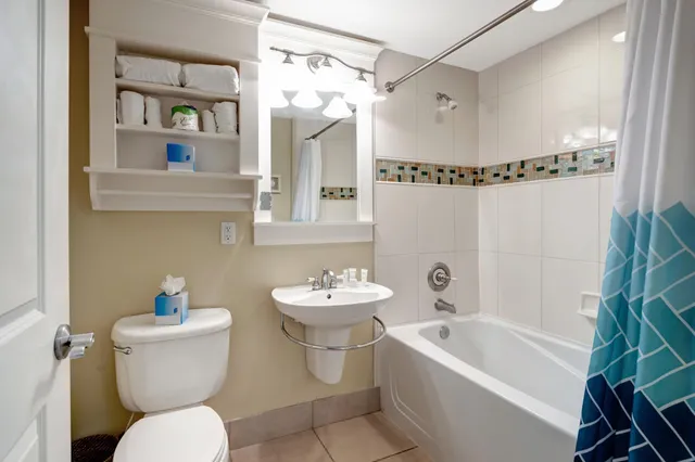 a bathroom with a sink a mirror a toilet and a bathtub