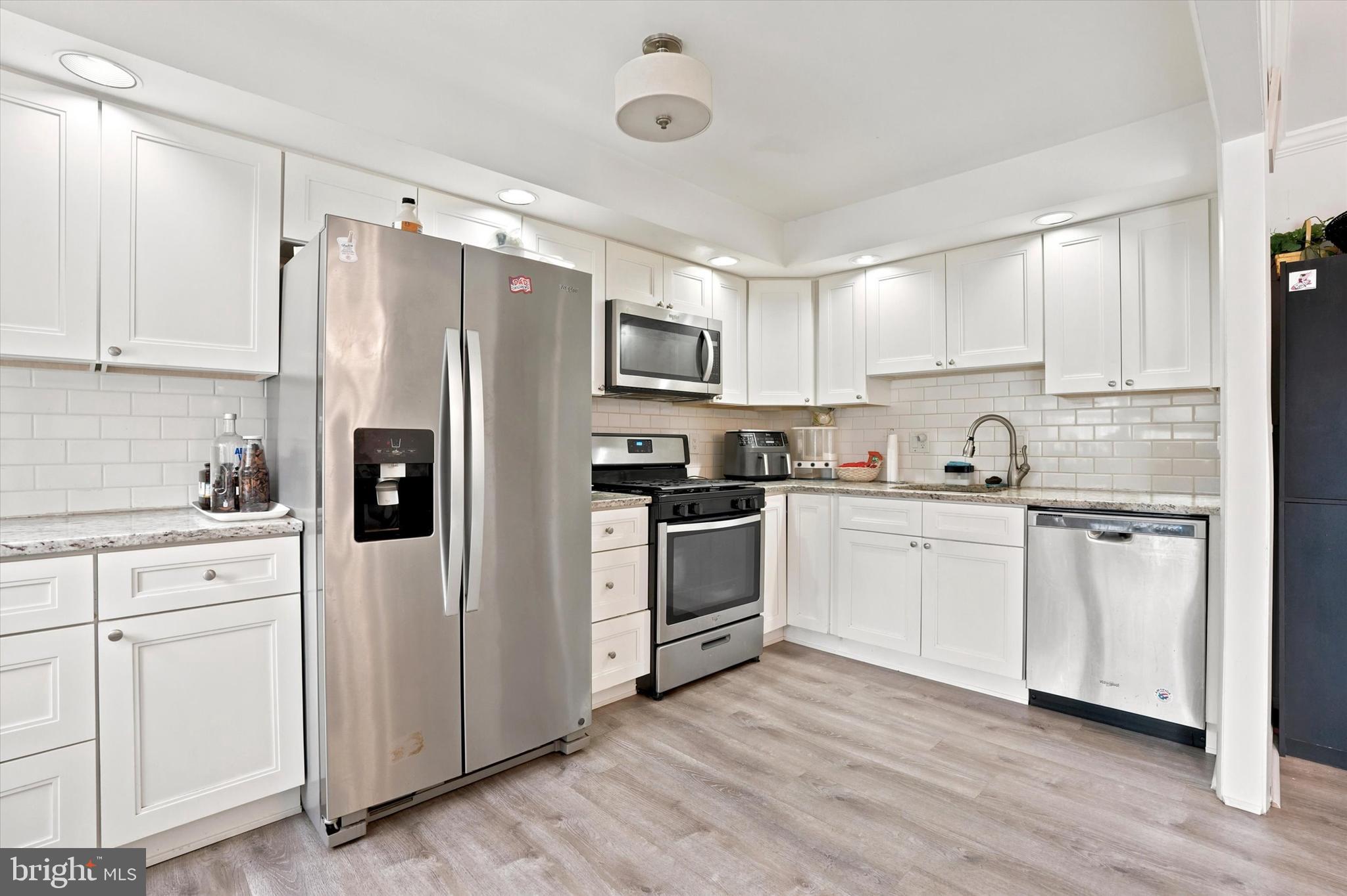 3435 Vinton Road Philadelphia, PA 19154 - Photo 9 of 25 a kitchen with white cabinets white stainless steel appliances and refrigerator