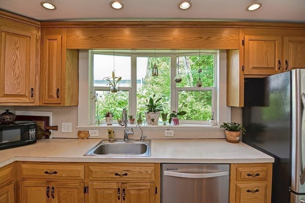 158 Union Street Randolph, MA 02368 - Photo 12 of 41 a kitchen with stainless steel appliances white cabinets and a window