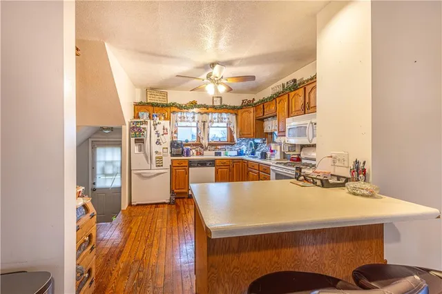 a large kitchen with a table chairs stove and wooden floor