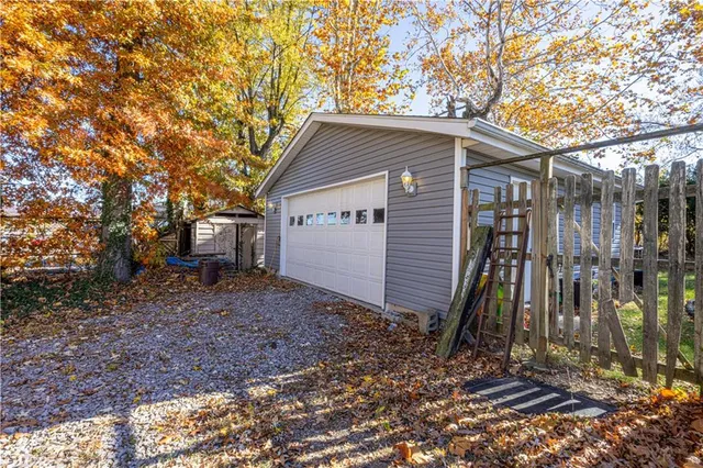 a view of a house with a yard and large tree