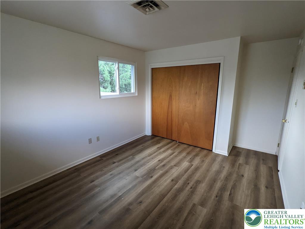 745 Easton Road, Unit 2 Hellertown, PA 18055 - Photo 7 of 12 an empty room with wooden floor closet and windows