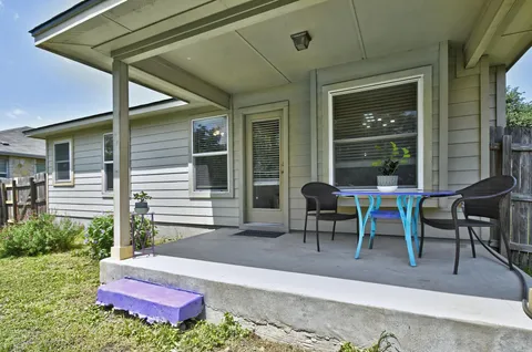 a view of a backyard with table and chairs and potted plants