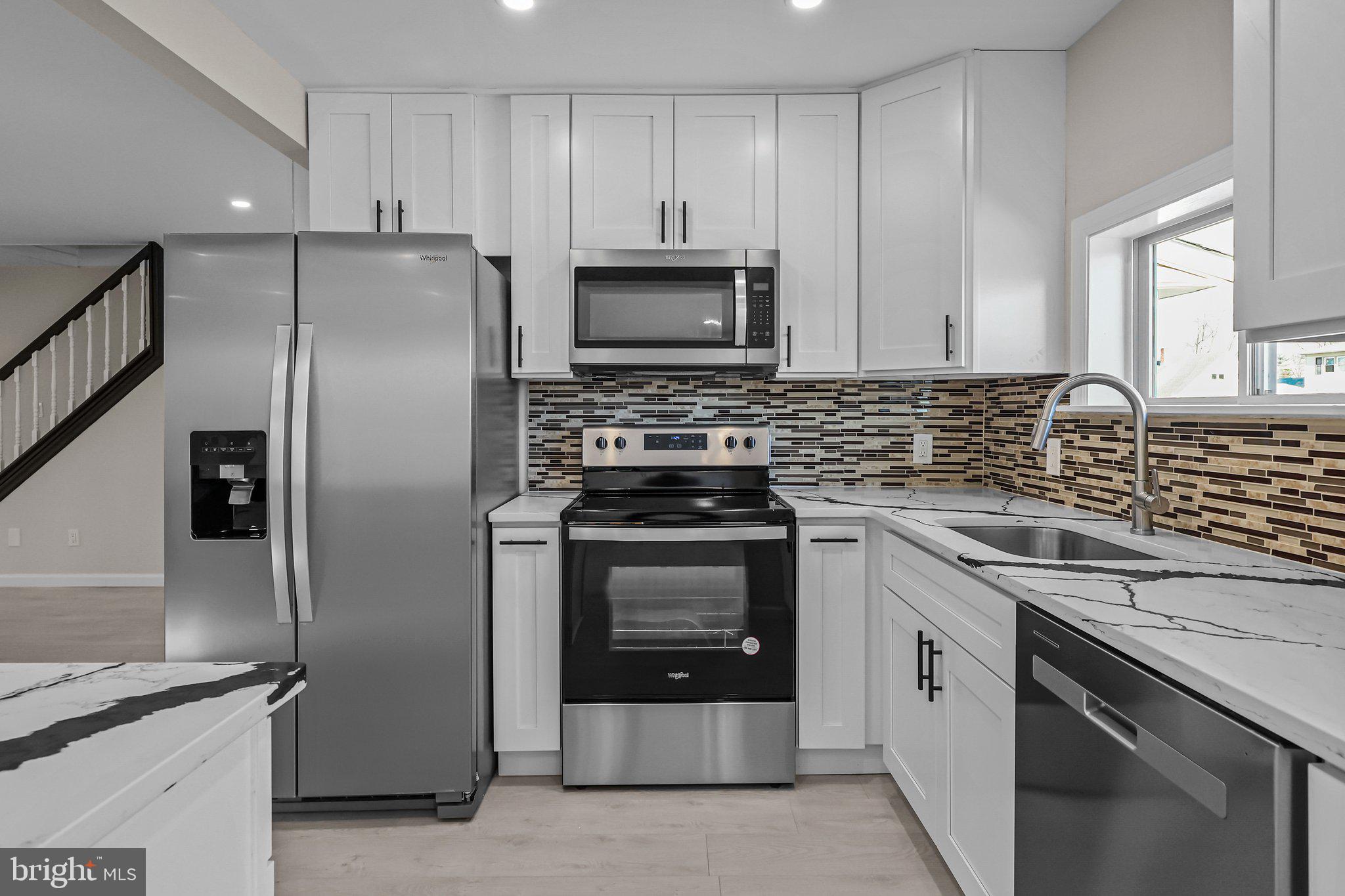 121 Goldengate Road Levittown, PA 19057 - Photo 14 of 32 a kitchen with stainless steel appliances granite countertop a stove a refrigerator and a sink