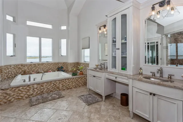 a bathroom with a tub a sink and a large mirror