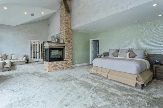 a spacious bedroom with a bed and a fireplace