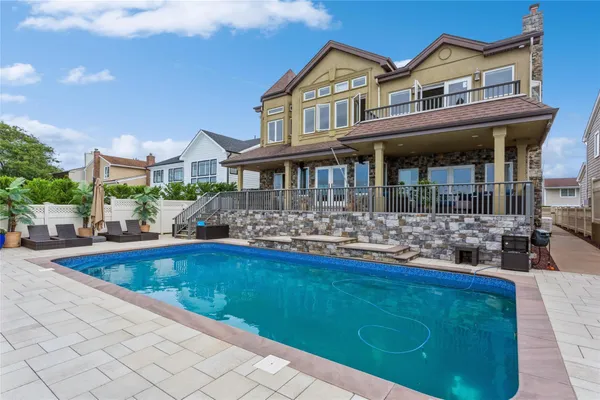 a front view of house and yard with swimming pool and furniture