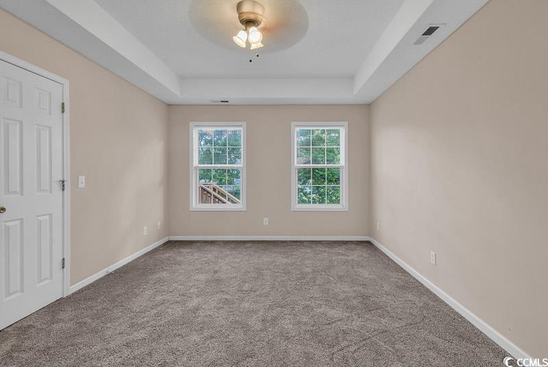 4672 Lightkeepers Way, Unit 50E Little River, SC 29566 - Photo 11 of 19 Unfurnished room featuring carpet, ceiling fan, and a tray ceiling
