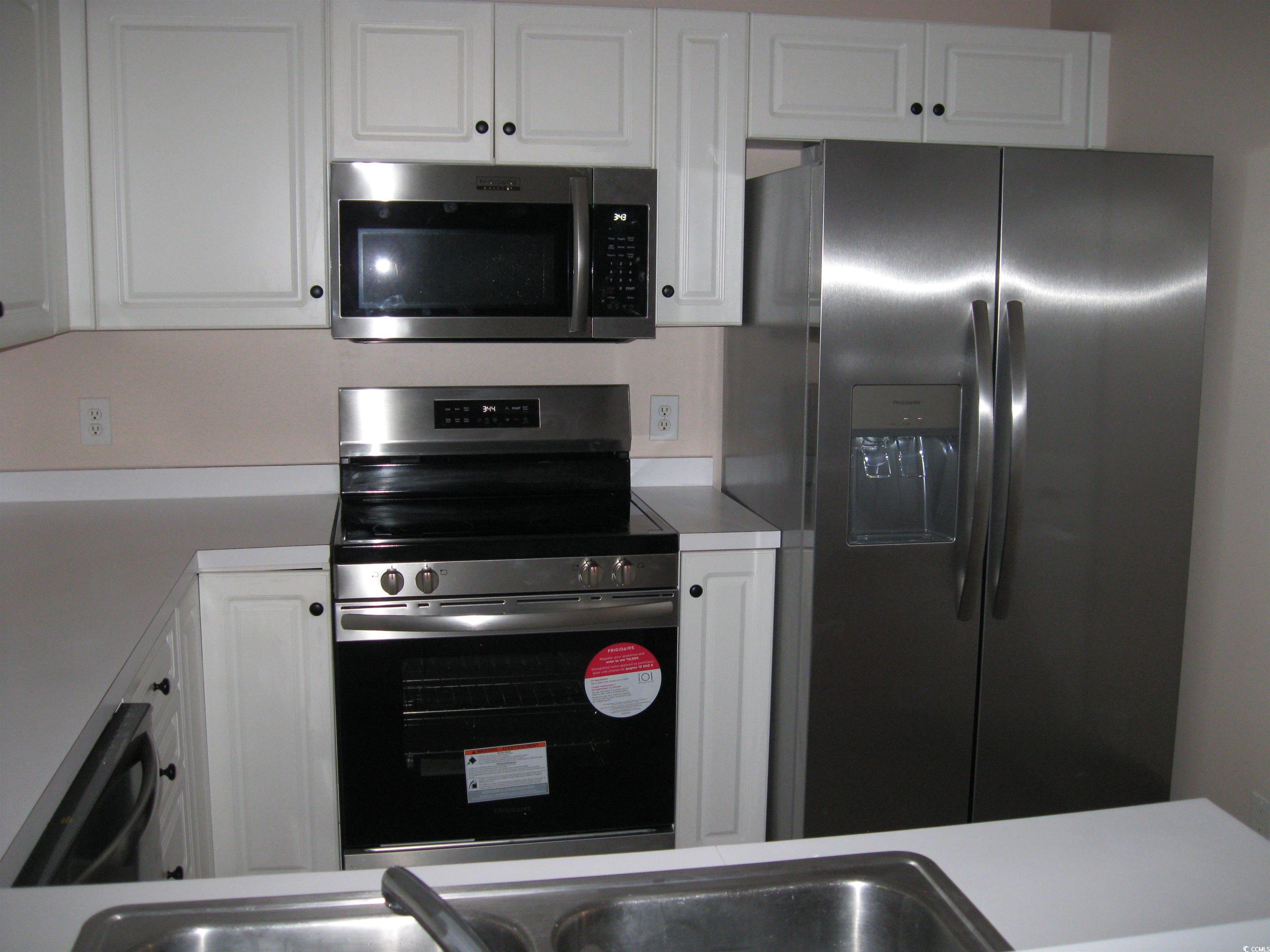 4672 Lightkeepers Way, Unit 50E Little River, SC 29566 - Photo 6 of 19 Kitchen with white cabinetry, light countertops, and appliances with stainless steel finishes