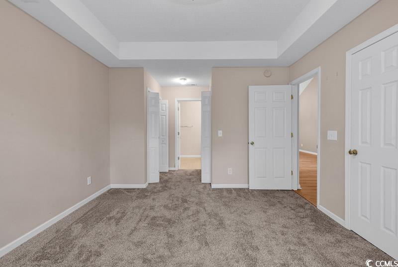 4672 Lightkeepers Way, Unit 50E Little River, SC 29566 - Photo 10 of 19 Unfurnished bedroom featuring a raised ceiling and light colored carpet