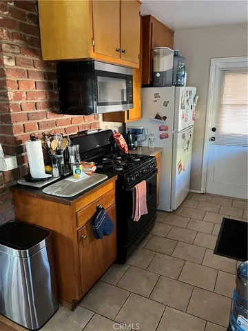 a kitchen with stainless steel appliances a stove a refrigerator a sink a counter top space and cabinets