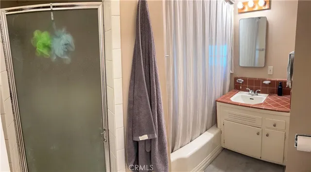 a bathroom with a sink and mirror with shower curtain