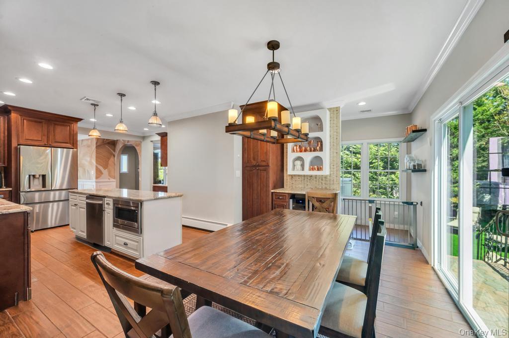 357 Wynsum Avenue Merrick, NY 11566 - Photo 24 of 40 a view of a dining room and livingroom with furniture wooden floor a chandelier