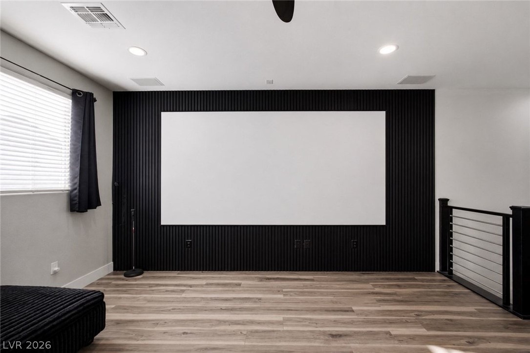 11009 Prairie Grove Road Las Vegas, NV 89179 - Photo 33 of 49 An inviting media room features rich hardwood flooring and a vast projection screen for cinematic experiences.