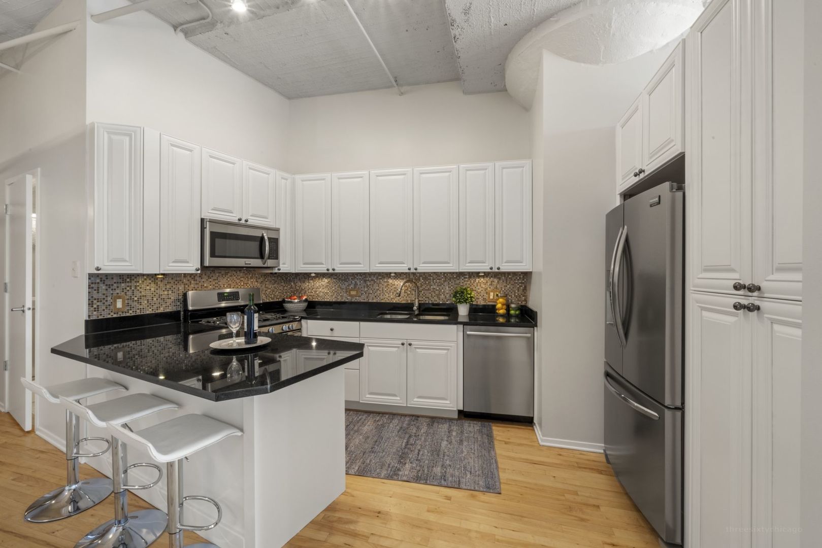 1530 South State Street, Unit 607 Chicago, IL 60605 - Photo 11 of 29 a kitchen with stainless steel appliances granite countertop a refrigerator a stove a sink and white cabinets