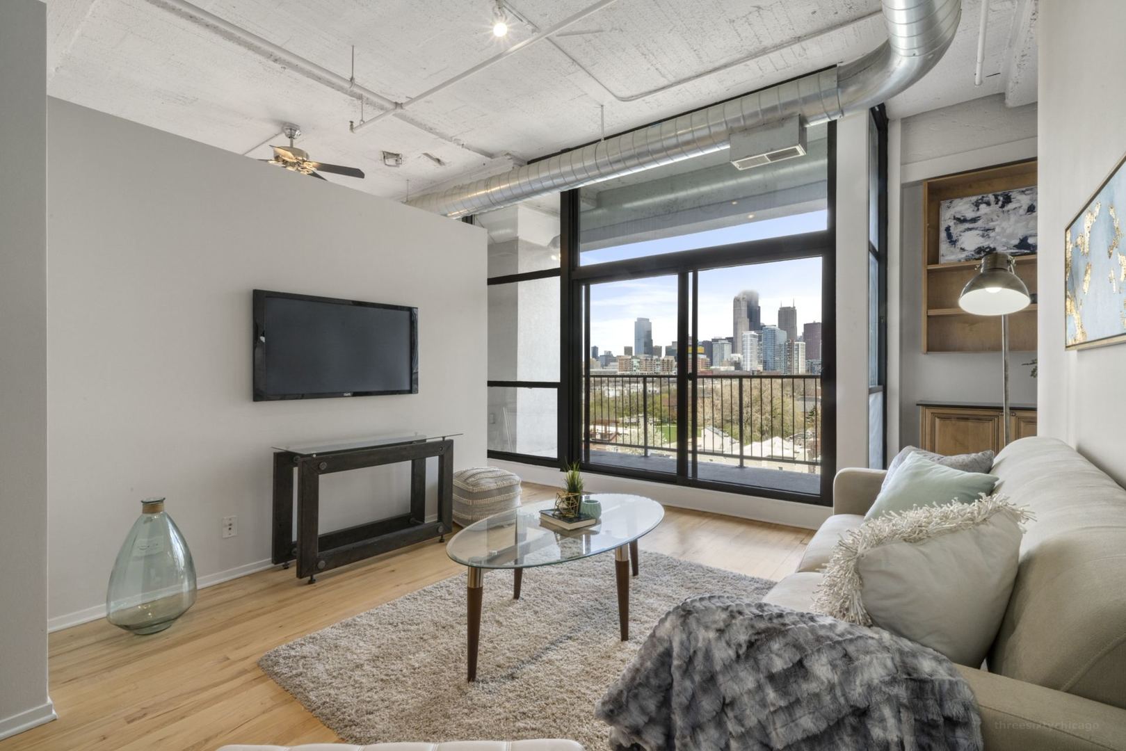 1530 South State Street, Unit 607 Chicago, IL 60605 - Photo 6 of 29 a living room with furniture a flat screen tv and a floor to ceiling window