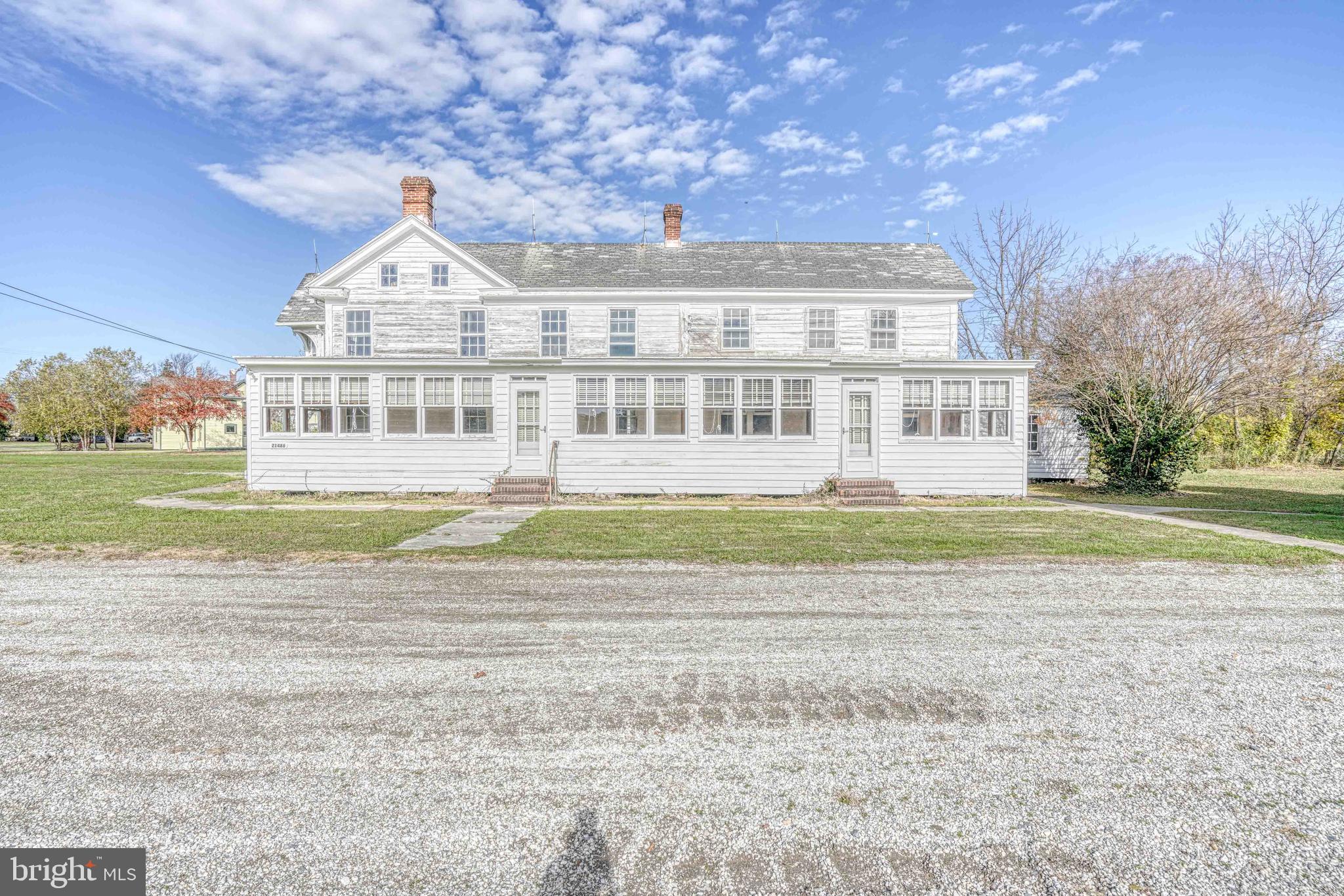 21486 Mission Road Tilghman, MD 21671 - Photo 13 of 32 a view of a big house next to a yard with big trees