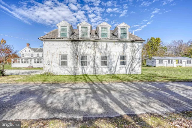 a view of a house with a yard and pathway