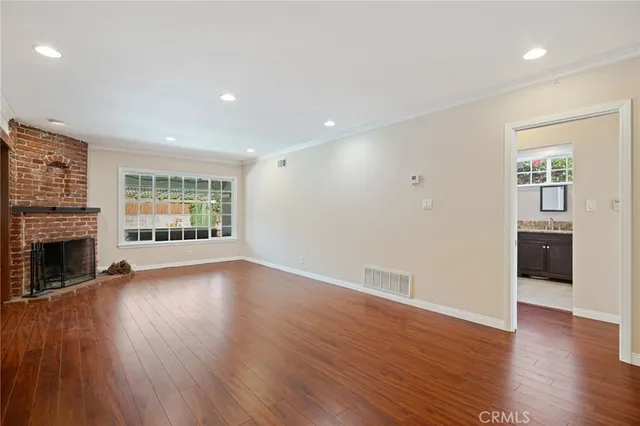 a view of an empty room with a window and fireplace