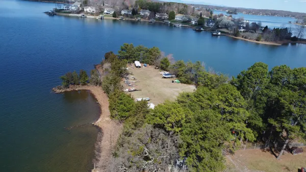 an aerial view of a house with a yard and trees all around