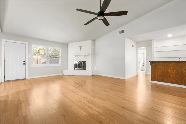 a view of empty room with wooden floor and window