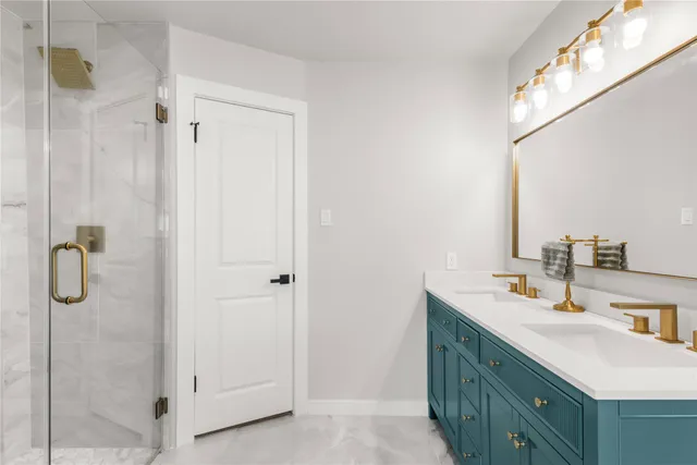 a bathroom with a double vanity sink mirror and shower