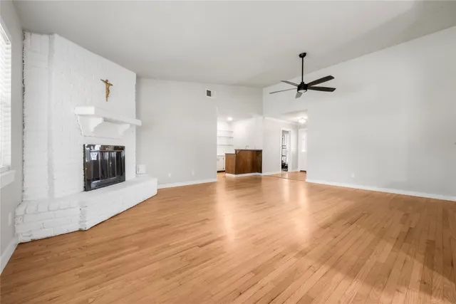 a view of empty room with wooden floor and fireplace