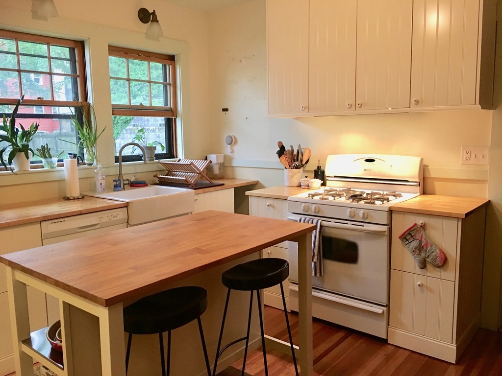 a kitchen with a stove and a white wooden cabinets