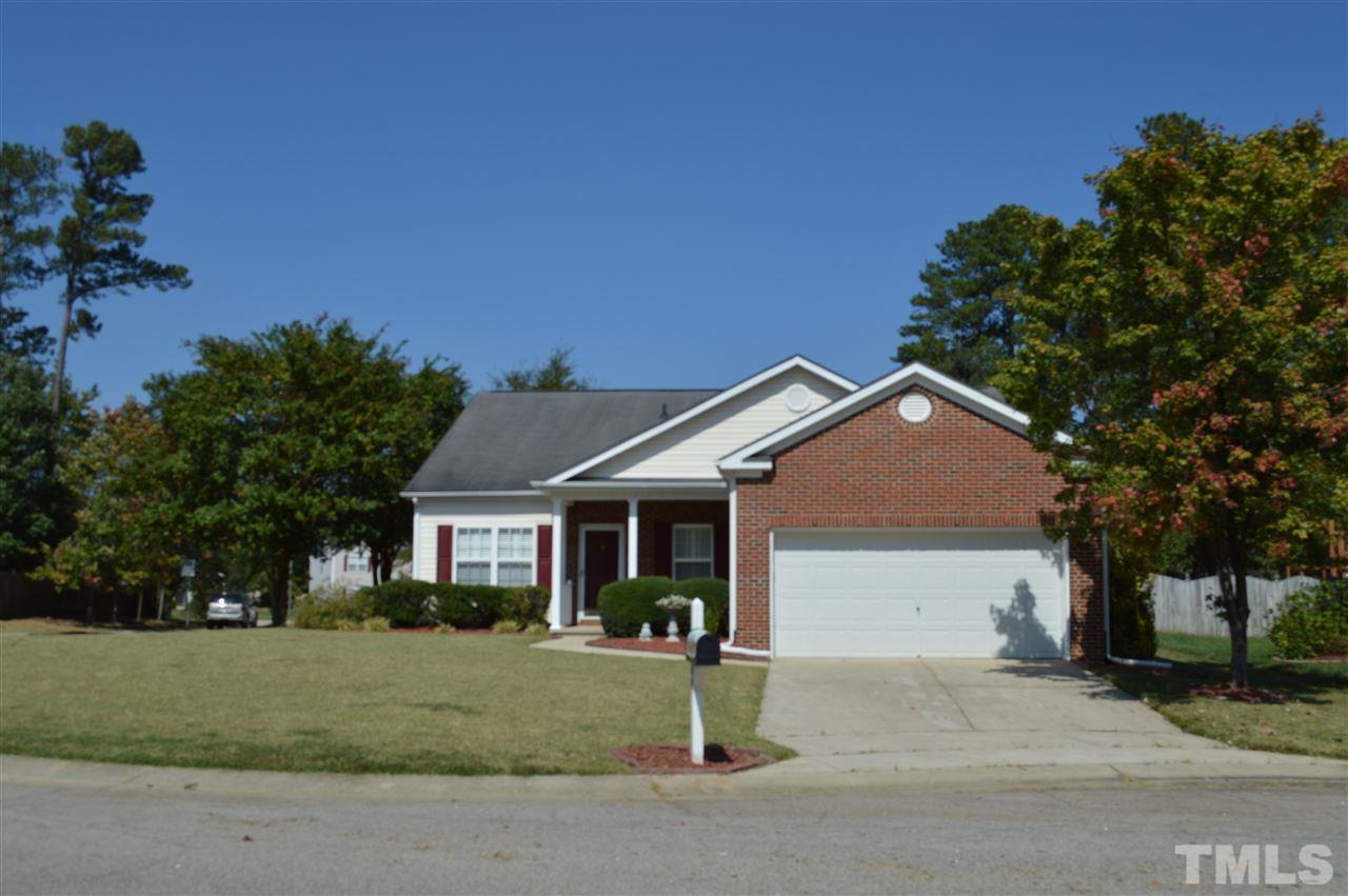 a front view of a house with a garden and trees