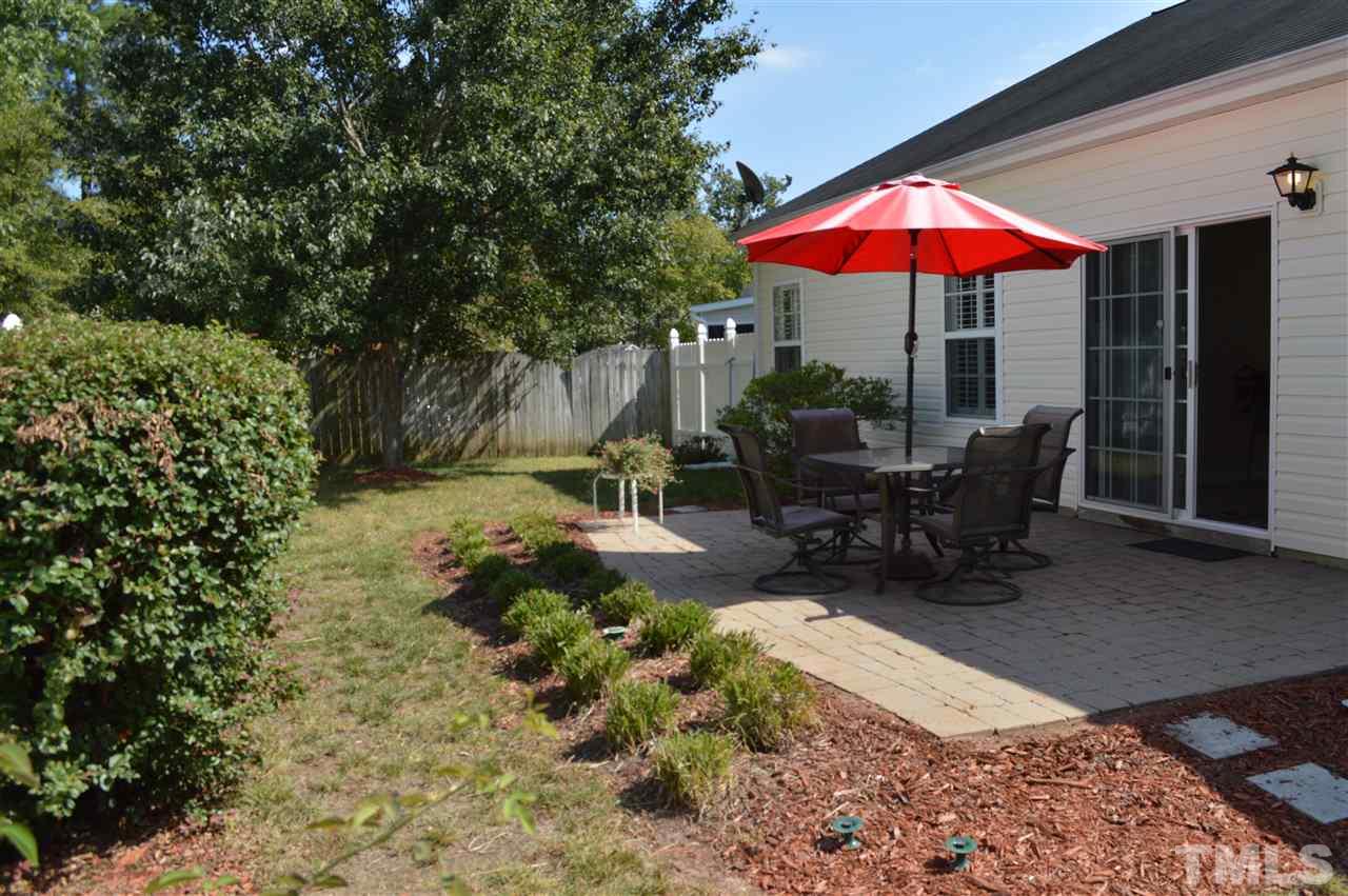 8508 Neuse Garden Drive Raleigh, NC 27616 - Photo 28 of 30 a view of a dinning tables and chairs under an umbrella in backyard of house