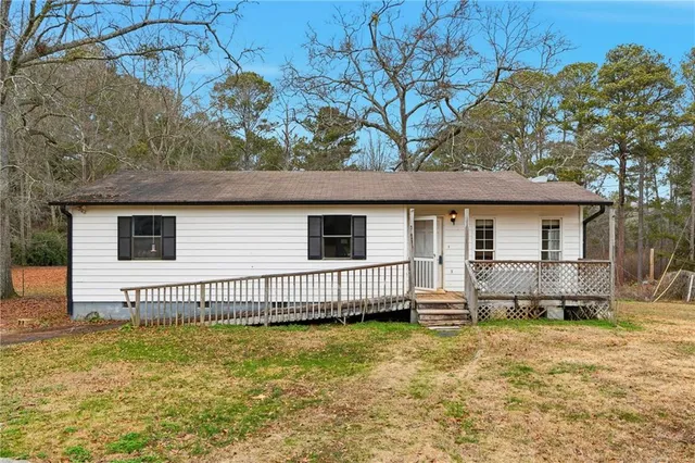 a view of a house with backyard and sitting area