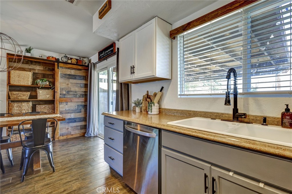 15936 Dauchy Avenue Riverside, CA 92508 - Photo 13 of 25 a kitchen with granite countertop a sink appliances cabinets and wooden floor