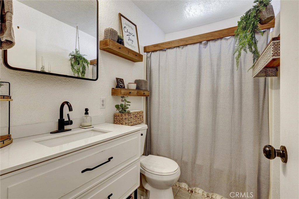15936 Dauchy Avenue Riverside, CA 92508 - Photo 16 of 25 a bathroom with a sink a toilet and a mirror