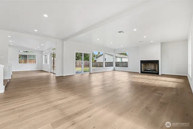 an empty room with wooden floor and fireplace