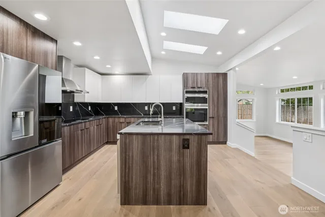 a kitchen with stainless steel appliances granite countertop a sink and stove