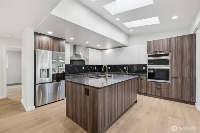a kitchen with stainless steel appliances granite countertop a sink a stove and a refrigerator