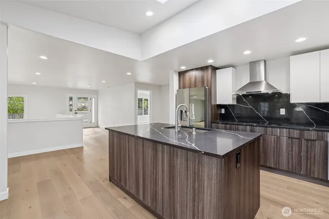 a kitchen with stainless steel appliances granite countertop a sink and a large window