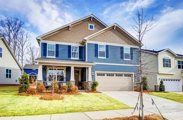 a view of house with yard and sitting area