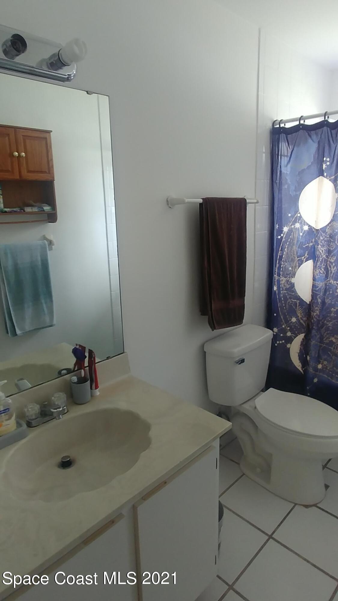 604 Ridge Club Drive, Unit 96 Melbourne, FL 32934 - Photo 13 of 17 a bathroom with a sink toilet and mirror