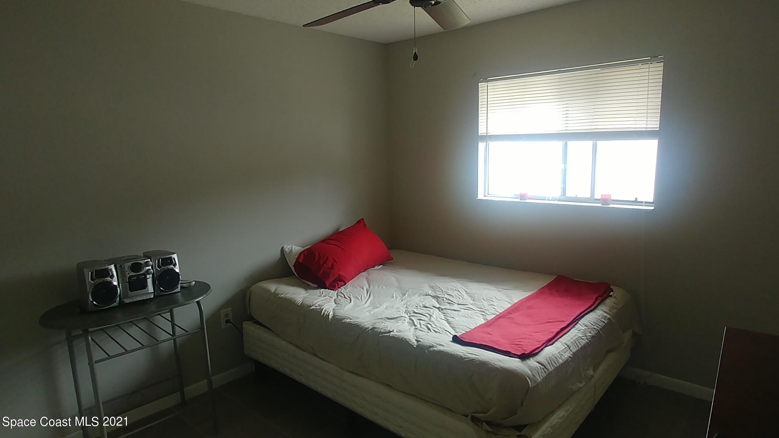 604 Ridge Club Drive, Unit 96 Melbourne, FL 32934 - Photo 14 of 17 a bedroom with a bed and a window