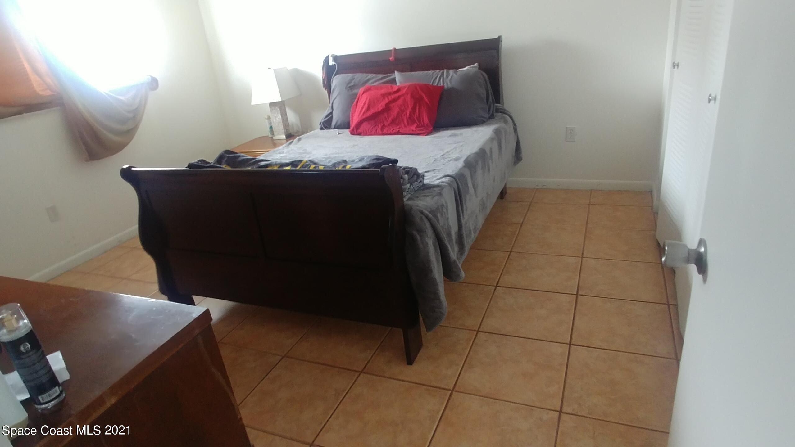 604 Ridge Club Drive, Unit 96 Melbourne, FL 32934 - Photo 15 of 17 a bedroom with a bed and a mirror