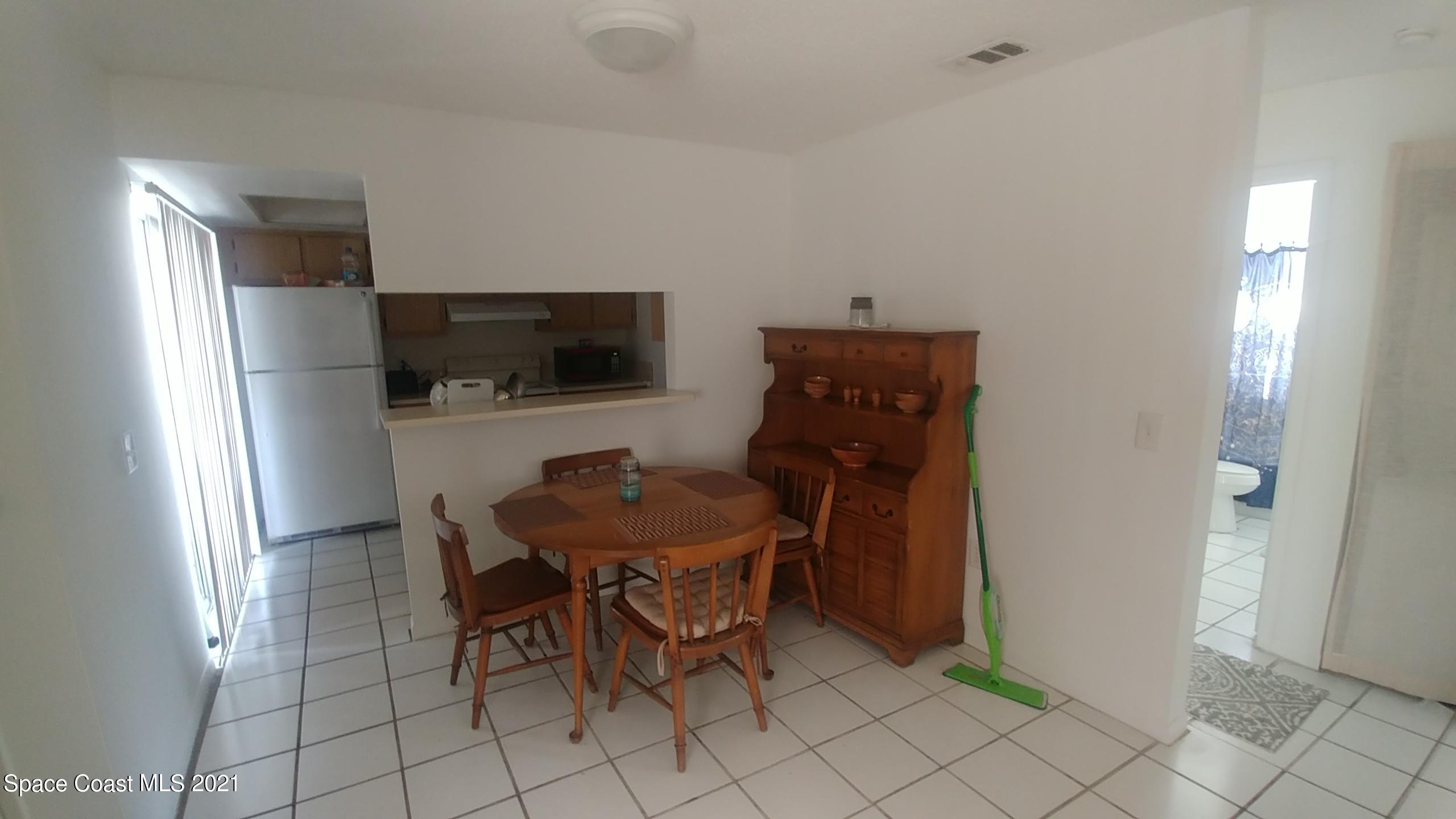 604 Ridge Club Drive, Unit 96 Melbourne, FL 32934 - Photo 9 of 17 a dining room with furniture and a flat screen tv