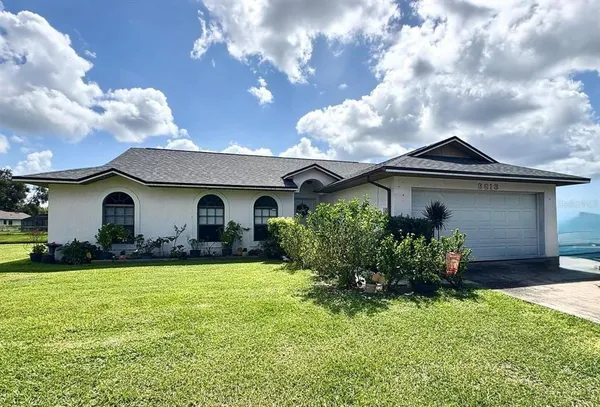 a front view of house with yard and garage